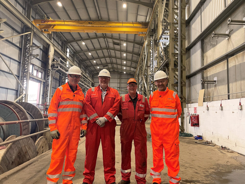 4 men in boiler suits