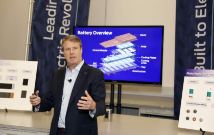 man giving a speech in front of a display