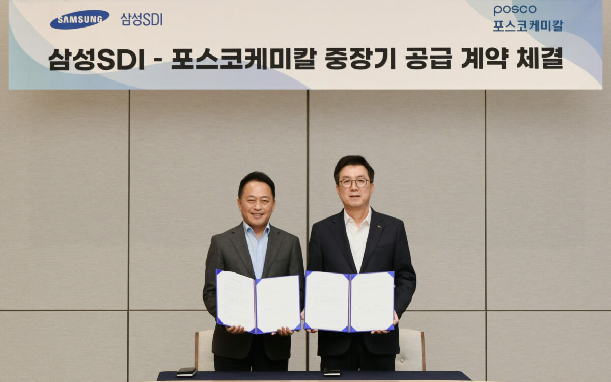 2 men holding up contracts