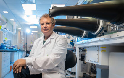 man in white lab coat sitting
