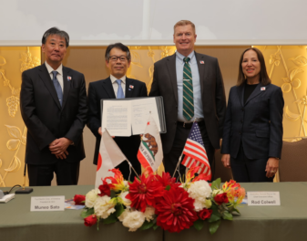 Four people smiling after signing a contract