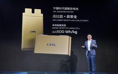 man in front of pic of batteries