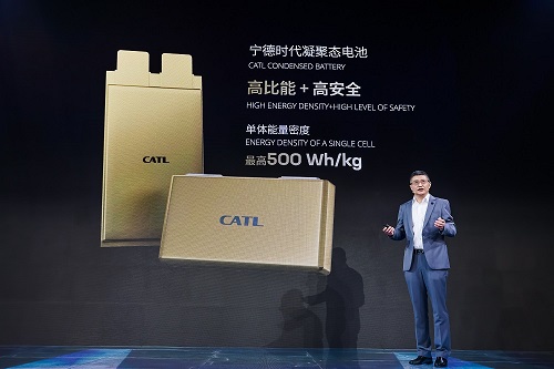 man in front of pic of batteries