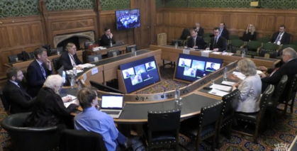 committee hearing, people seated at tables