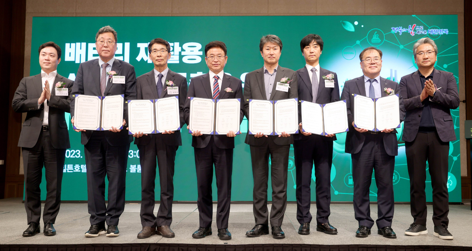 8 men in a row holding up documents
