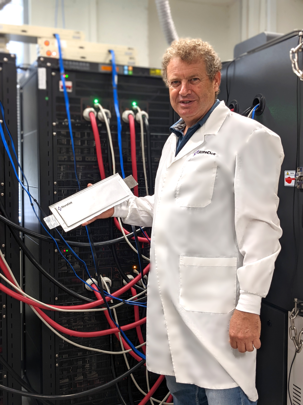 man in lab coat holding battery