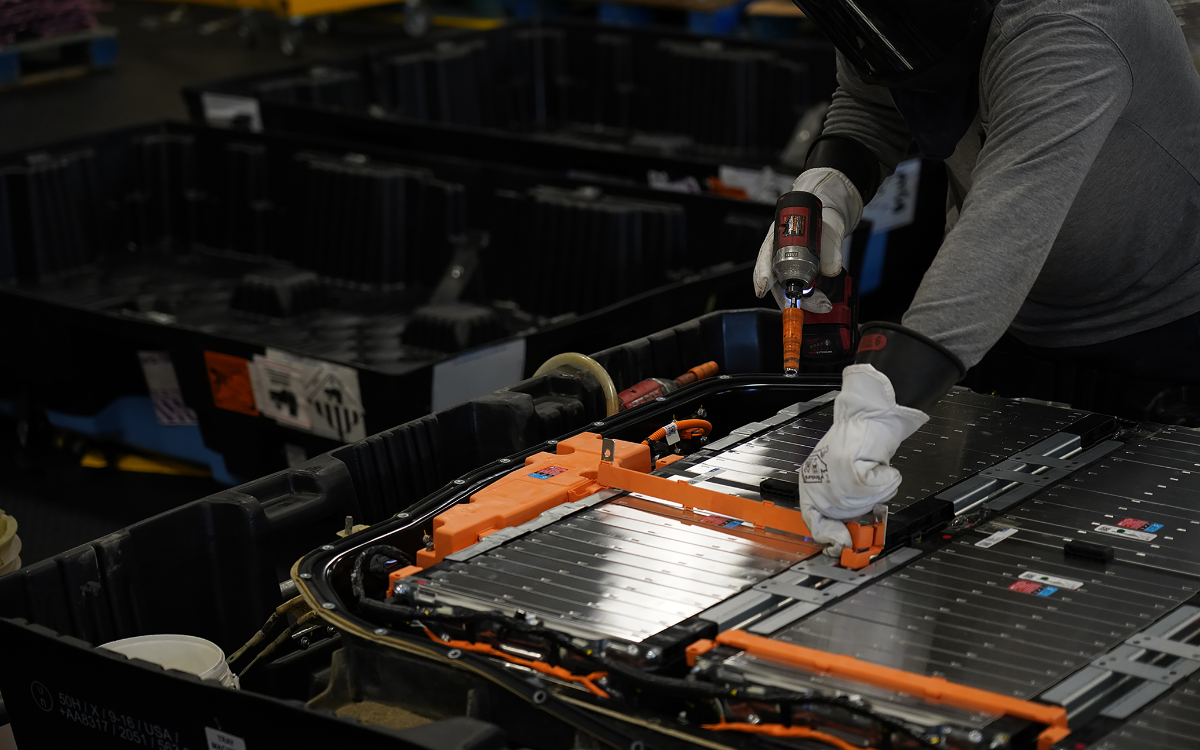 worker disassembling a battery