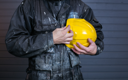 miner holding a yellow helmet