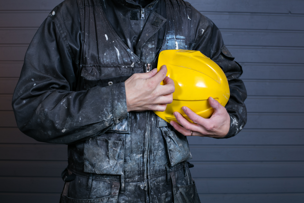 miner holding a yellow helmet