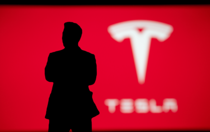 silhouette of man in front of tesla logo