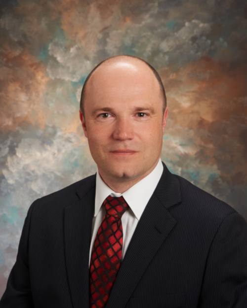 head and shoulders of bald man in suit and tie