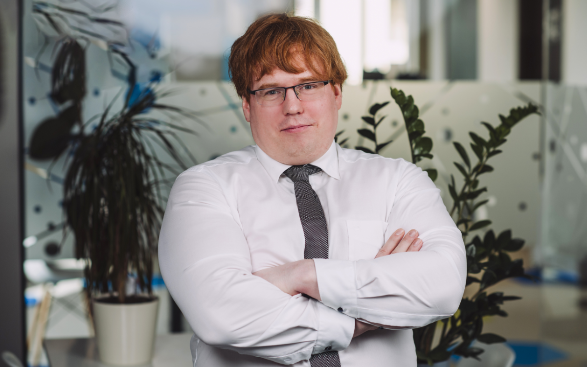 man in white shirt and tie with arms folded
