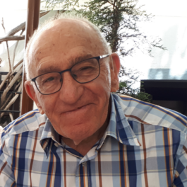 head and shoulders of man in checked shirt and wearing glasses