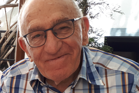 head and shoulders of man in checked shirt and wearing glasses