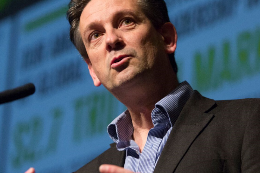 man speaking with hands held out