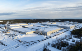 aerial view of gigafactory surrounded by snow