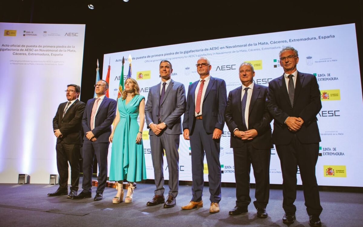 people standing in a row on a stage with big posters behind them