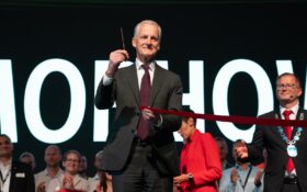 man in suit cutting ribbon