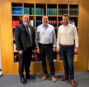 3 men in front of a bookcase